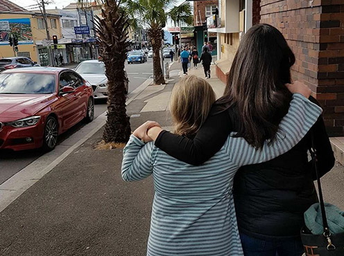 An NDIS participant and their mentor walking along the street